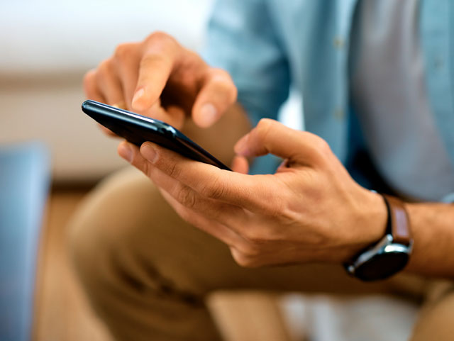 Detalle de manos interactuando con un dispositivos móvil