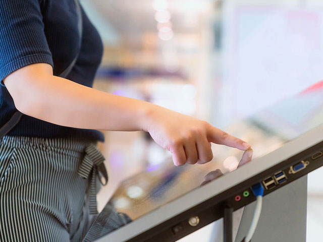 Una usuaria interactúa con un kiosko