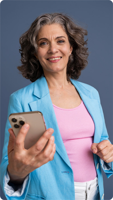 Mujer de mediana edad mirando a cámara con el móvil en la mano
